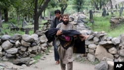 مردی در ولایت کنر افغانستان، قربانی خردسالی را در آغوش گرفته است. قربانی‌ای از زلزلۀ ۳۱ اگست که جان بسیاری را گرفت و چندین قریه را ویران ساخت.