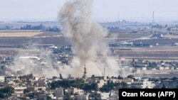 Suriya shimolida Ras al-Ayn shahri uzra tutun ko‘kka o‘rlamoqda. 2019, 15 oktabr.