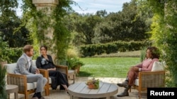 Канзаада Гарри жана жубайы Меган маек учурунда. 