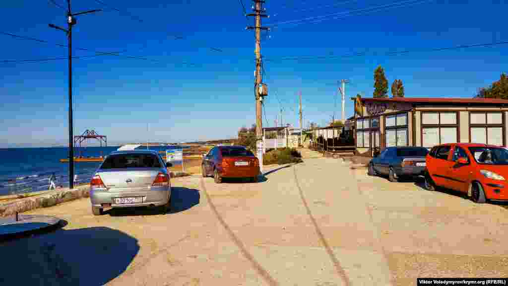 Deñiz yanında bir qaç maşna tura. Birirsi mında raatlanmağa, başqaları ise balıq tutmağa keldi