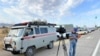 A TV cameraman stands at a police roadblock outside the military base where the explosion occurred on August 27.