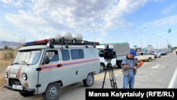 A TV cameraman stands at a police roadblock outside the military base where the explosion occurred on August 27.