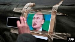 Ресей президенті Владимир Путиннің Киевтегі Тәуелсіздік алаңындағы шатырға ілінген карикатурасы. Киев, 2 наурыз 2014 жыл.