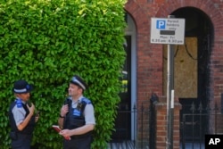 Співробітники поліції стоять біля пошкоджених вогнем дверей будинку, що належить прем'єр-міністру Великої Британії Кіру Стармеру в районі Кентиш-Таун у Лондоні, вівторок, 13 травня 2025 року