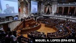 Президент Украины Владимир Зеленский (на экране) во время обращения по видеосвязи к парламенту Португалии. 21 апреля 2022 года.