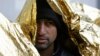 A migrant covers himself with a thermal blanket as he waits in line to get food at a migrant center in Bihac, close to Bosnia's border with Croatia, in November.