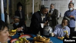 Erkek adamlar Remezan aýynda agyz açýarlar. Hotandaky Jaman metjidi. 2021-nji ýylyň 29-njy apreli.