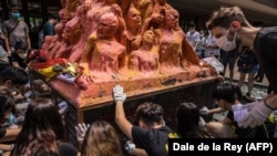 Հոնկոնգի համալսարանի ուսանողները մաքրում են 1989 թվականի իրադարձությունների զոհերի հիշատակին նվիրված «Ամոթի սյուն» հուշարձանը, 4-ը հունիսի, 2020թ.