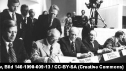 Хэльсынскія пагадненьні падпісваюць канцлер ФРГ Гэльмут Шміт, старшыня Дзяржаўнай Рады ГДР Эрых Гонэкэр, прэзыдэнт ЗША Джэральд Форд і аўстрыйскі канцлер Бруна Крайскі