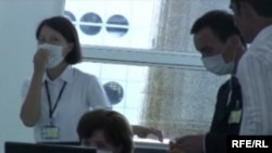 Казакстан: аэропортто кызматкерлер маска кийип иштеп жатышат. 30-июль, 2009-жыл