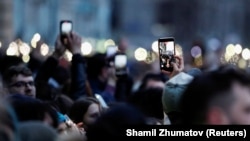 Supporters of Aleksei Navalny hold up cell phones during a rally in Moscow on April 21.
