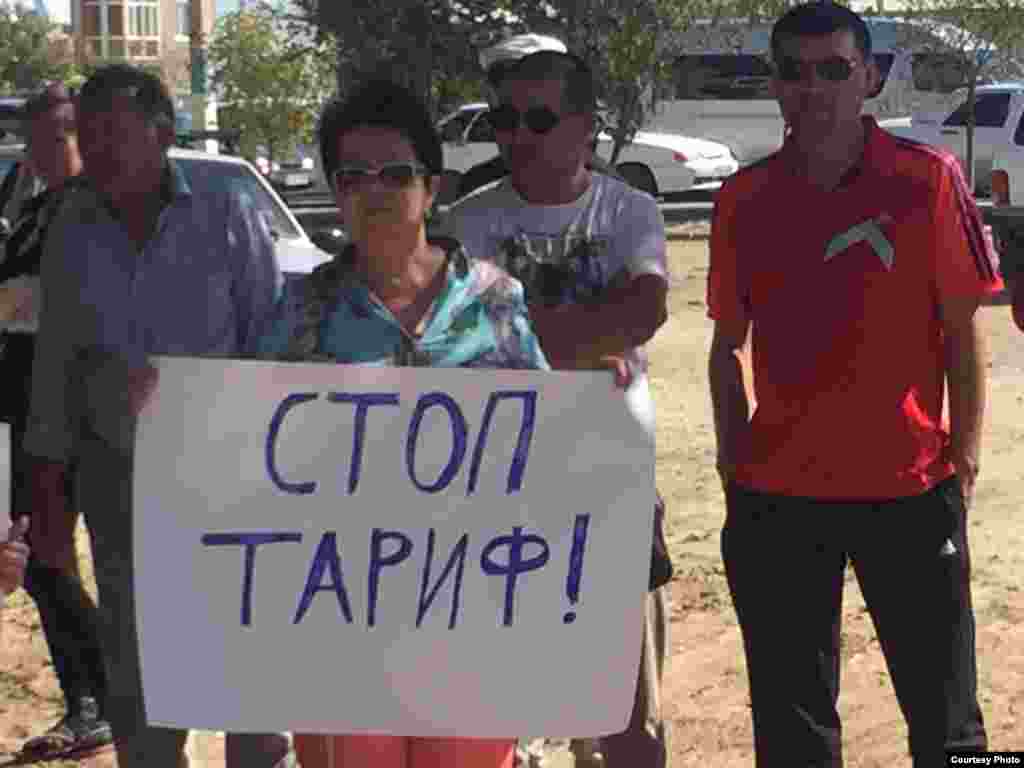 Участница митинга держит плакат: &quot;Стоп тариф!&quot;
