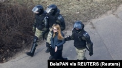 Коопсуздук күчтөрү бир айымды кармап кетүүдө. Минск. 2021-жылдын 27-марты.