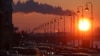 Russia -- Pipes of a thermal power plant are seen during sunset, with cars stuck in a traffic jam in the foreground, in St. Petersburg, 15Feb2011