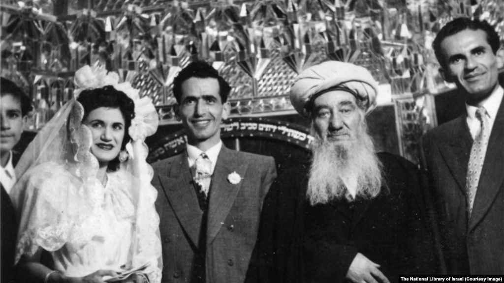 برگزاری یک عروسی یهودی در دههٔ ۱۹۵۰ در مکانی نامشخص در ایران. این مراسم توسط حاخام شلومو کهن صدیق (وسط سمت راست)، رهبر روحانی یهودیان ایران، برگزار شد.نوشته عبری پشت گروه به فرازی از کتاب مقدس یهودیان اشاره دارد: «همسرت مانند تاک بارور در درون خانه‌ات باشد، و فرزندانت مانند جوانه‌های زیتون در اطراف سفره‌ات».