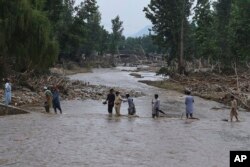 د بونېر په بیشوڼۍ کلي کې یوشمېر کسان د سېلاب پر مهال له خوړه تېرېږي - د اګست ۱۷مې انځور.