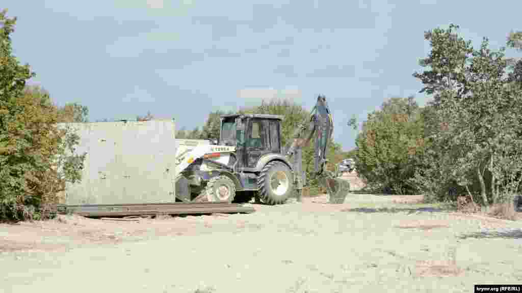 ... а поруч з будівлею стояв захований за великим щитом трактор