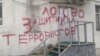The graffiti on the wall of Lev Ponomaryov's office saying "Hide-out for the defender of terrorists"