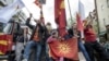 Macedonian protesters wave flags while riding an excavator during a demonstration against a deal to form a new government between the Social Democrats and ethnic Albanian parties. (file photo)