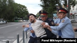 Казак полициясы Алматыдагы нааразылык акцияларынын катышуучусун кармап кетип жаткан учуру. 12-июнь, 2019-жыл. 