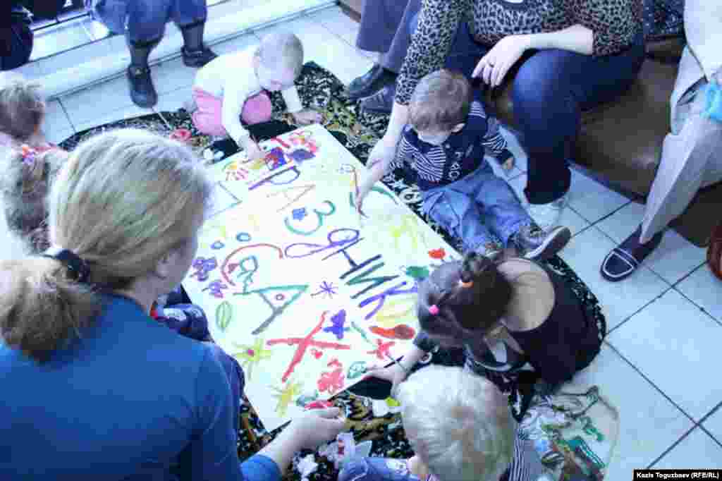 Малыши пробуют рисовать кистью.