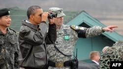 Prezidenti Obama Günorta Koreýa bilen Demirgazyk Korýanyň araçägindäki “Demilitarizasiýa zonasy” diýlip atlandyrylýan ýerde Demirgazyk Korýanyň territoriýasyna dürbi arkaly syn edýär. 25-nji mart, 2012. 
