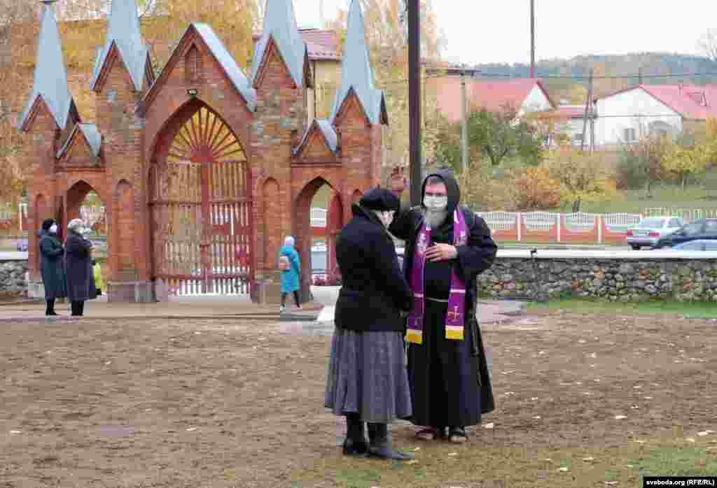 Католицький священник благословляє жінку в День пам&#39;яті предків на цвинтарі в Ів&#39;янці, Білорусь