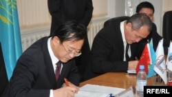 Генеральный директор компании Sinopec Engineering Чжу Хайсин (слева) и генеральный директор АНПЗ Талгат Байтазиев (справа) подписывают контракт на модернизацию завода. Атырау, 29 октября 2009 года. 