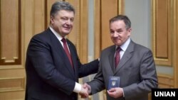 Президент України Петро Порошенко (ліворуч) вручає паспорт громадянина України Мішелю Терещенку. Київ, 21 березня 2015 року