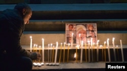 Armenia -- A man lights a candle during a memorial ceremony for six-month-old boy Seryozhai Avetisyan on Liberty Square in Yerevan, January 20, 2015