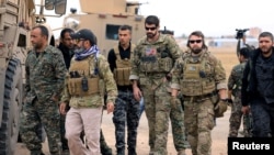 АКШнын аскер адамдары Сирия демократиялык  күчтөрүнүн өкүлдөрү менен Сирия-Түркия чек арасынын жанында. 4-ноябрь, 2018-жыл. 