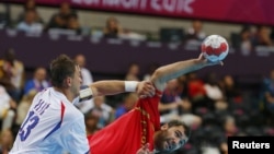 Испанский спортсмен Джон Канеллас (справа) и  сербский спортсмен Момир Илич Сербии во время матча мужского гандбола на Олимпийских играх в Лондоне, 29 июля 2012 года. 