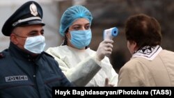 Медична працівниця перевіряє температуру у жінки на в’їзді до міста Вагаршапат, 16 березня 2020 року