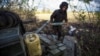 A Ukrainian soldier carries a shell to a tank at a position near a front line outside the town of Bakhmut. 