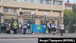 Люди, требующие освобождения своих родственников в Синьцзяне, стоят перед офисом ООН в Нур-Султане. 23 сентября 2021 года