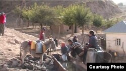 Дети и подростки набирают воду из арыка в сельской местности в Таджикистане. Иллюстративное фото.