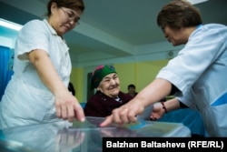 Пациентов, проживающих в Доме ветеранов, на избирательном участке в Алматы сопровождают медсестры. 20 марта 2016 года.