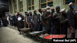 شماری از افراد بیکار برای دریافت کمک صف بسته اند