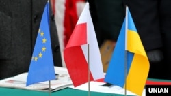 Прапори України, Польщі та ЄС під час закладання символічної капсули з інформацією про початок будівництва у Львові Центру польської культури та європейського діалогу – Польського дому. Львів, 6 листопада 2015 року