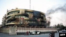 Smoke billows after anti government forces ransacked a government security facility, in Damascus, on December 8, 2024.