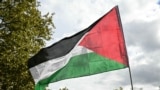 A protester waves a Palestinian flag during a march asking for the "recognition of the State of Palestine and the end of the genocide", in Paris on September 21, 2025.