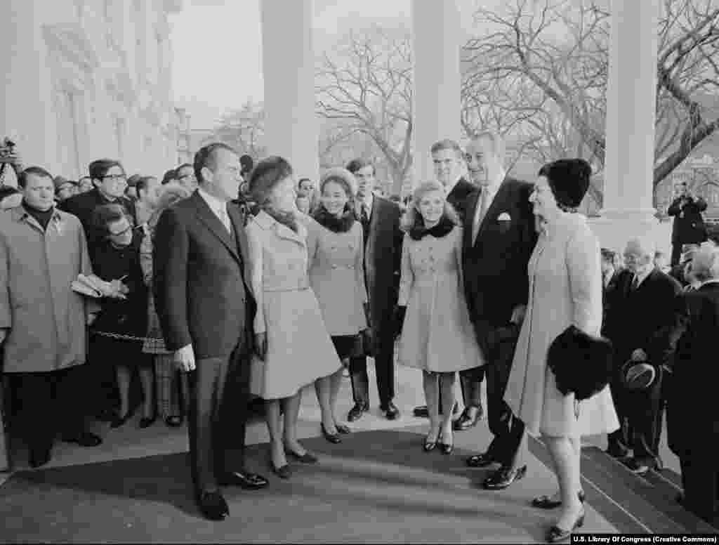 Президент Ричард Никсон (солдо) жана анын алдынкы президент Жонсон үй-бүлөөлөрү менен. Вашингтон, 20-январь, 1969-жыл. Никсон жогорку кызматка эки ирет шайланып, бирок &quot;Уотергейт&quot; жаңжалына байланыштуу экинчи мөөнөтүн аягына чыгарбай отставкага кеткен. &nbsp;