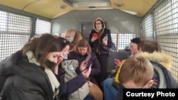 Оппозициячыл жыйындын кармалып бара жаткан  катышуучулары полициянын унаасында. Алардын арасында Карелиянын Петрозаводск шаарынан келген саясатчы да бар. Москва. 2021-жылдын 13-марты.