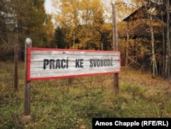 Реконструированный знак на месте трудового лагеря в Яхимове: «Труд освобождает»