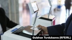 Шайлоо тилкесинде добуш берип жаткан шайлоочу. Бишкек. 17-ноябрь, 2024-жыл.