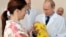 Владимир Путин в родильном доме в Калининграде берет новорожденного ребенка из рук его матери.