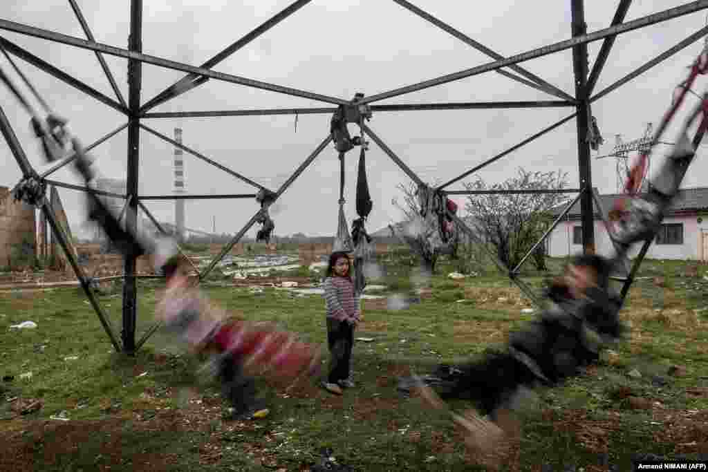 Цыганские дети на самодельных качелях из одежды возле убежища в поселке Племетина, Косово. 8 апреля - Международный день цыган.