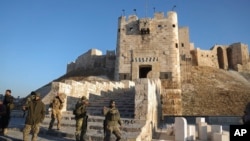 Syria - Opposition fighters take pictures with their cellphone next to the Old City in Aleppo, November 30, 2024. 