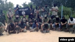 The speaker is the only one among the 22 men in the video who is not wearing a mask. "People should understand you're wearing a mask of Islam," he says of the Tajik mullah.