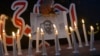 Свечи на фоне погибшего при взрыве в Пакистане оператора новостной службы. 
